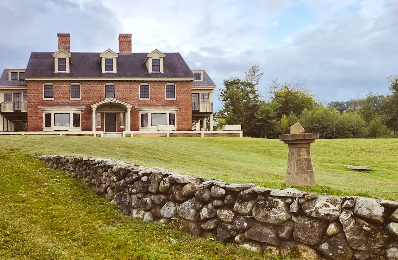 The brick inn above a stone wall and lawn